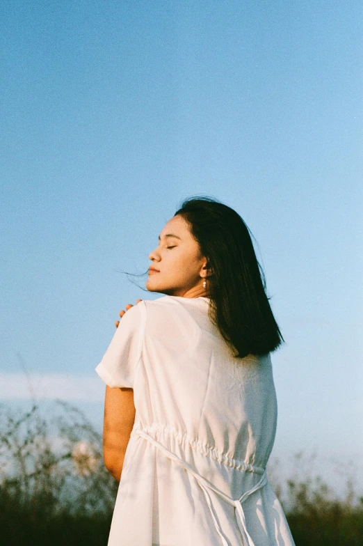 woman looking up at the sky in the field