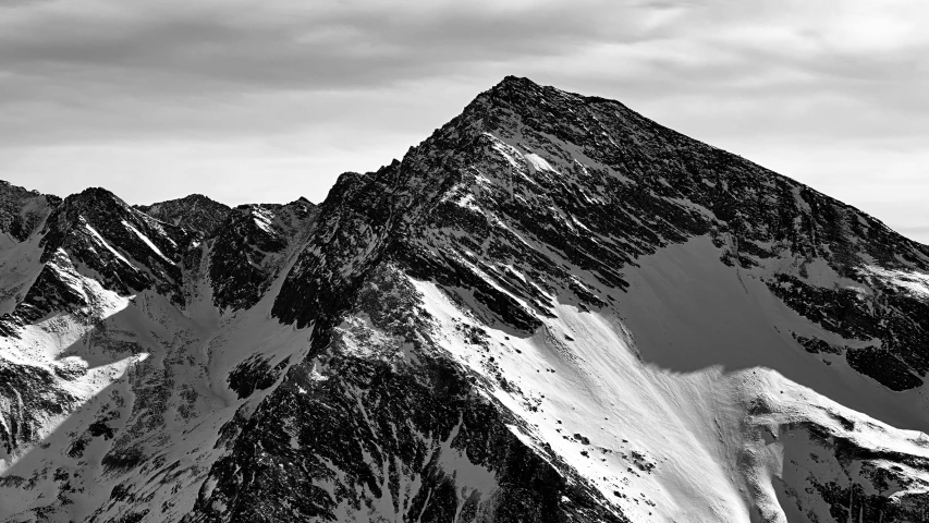 a black and white picture of some mountains with snow on them