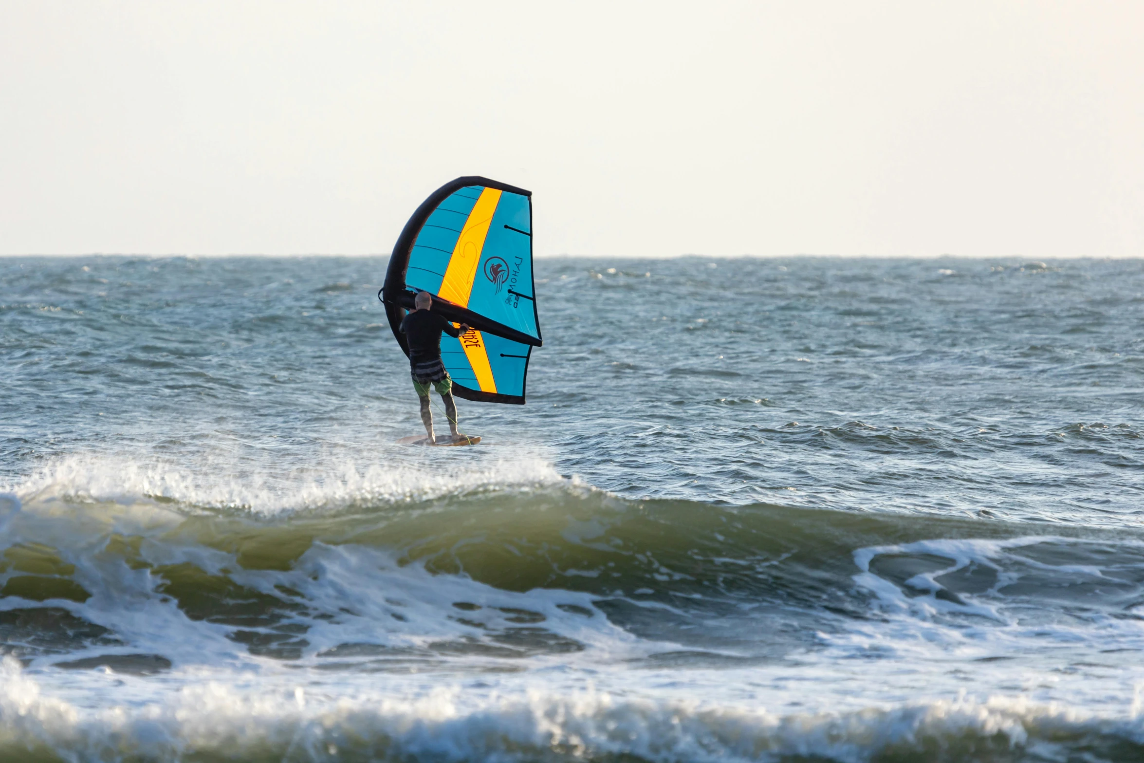 a man riding on top of waves while wind surfing