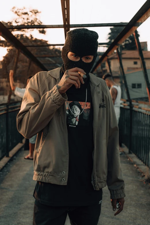 a man in a jacket and black hat is smoking a cigarette