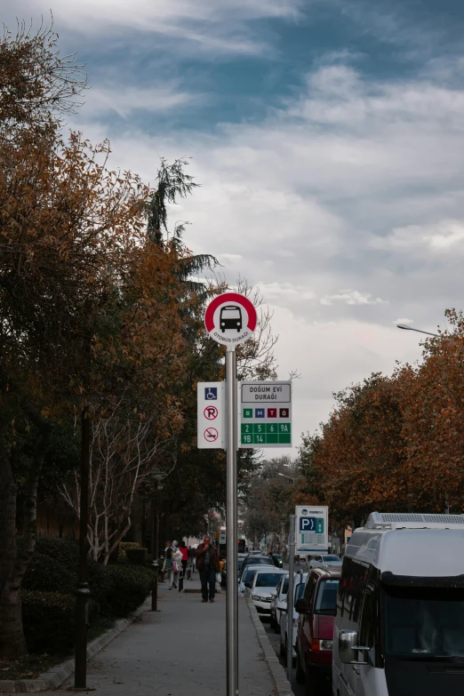 a red and white street sign sitting on the side of a sidewalk