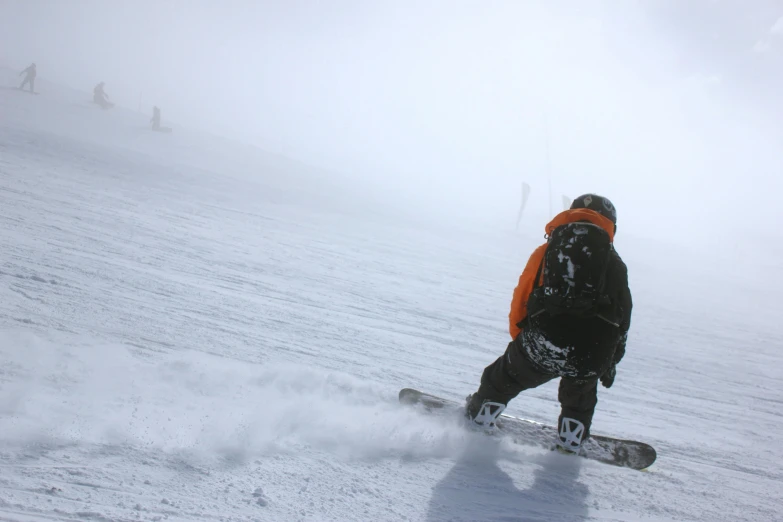 a man riding a snowboard down a snow covered slope