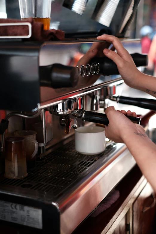 a woman pouring some latte into a coffee maker