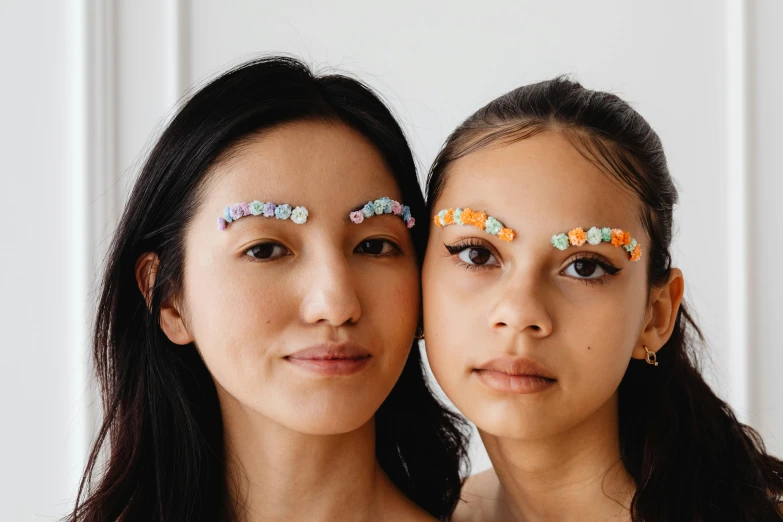 two young women with eye makeup in front of the camera