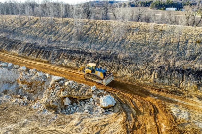 a tractor drives along a track that is partially under construction