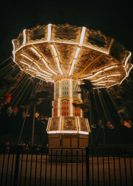 there is a carousel at night with its lights on