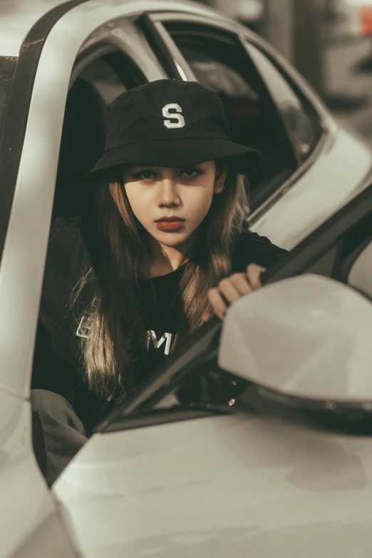 a girl in black cap leaning out the window