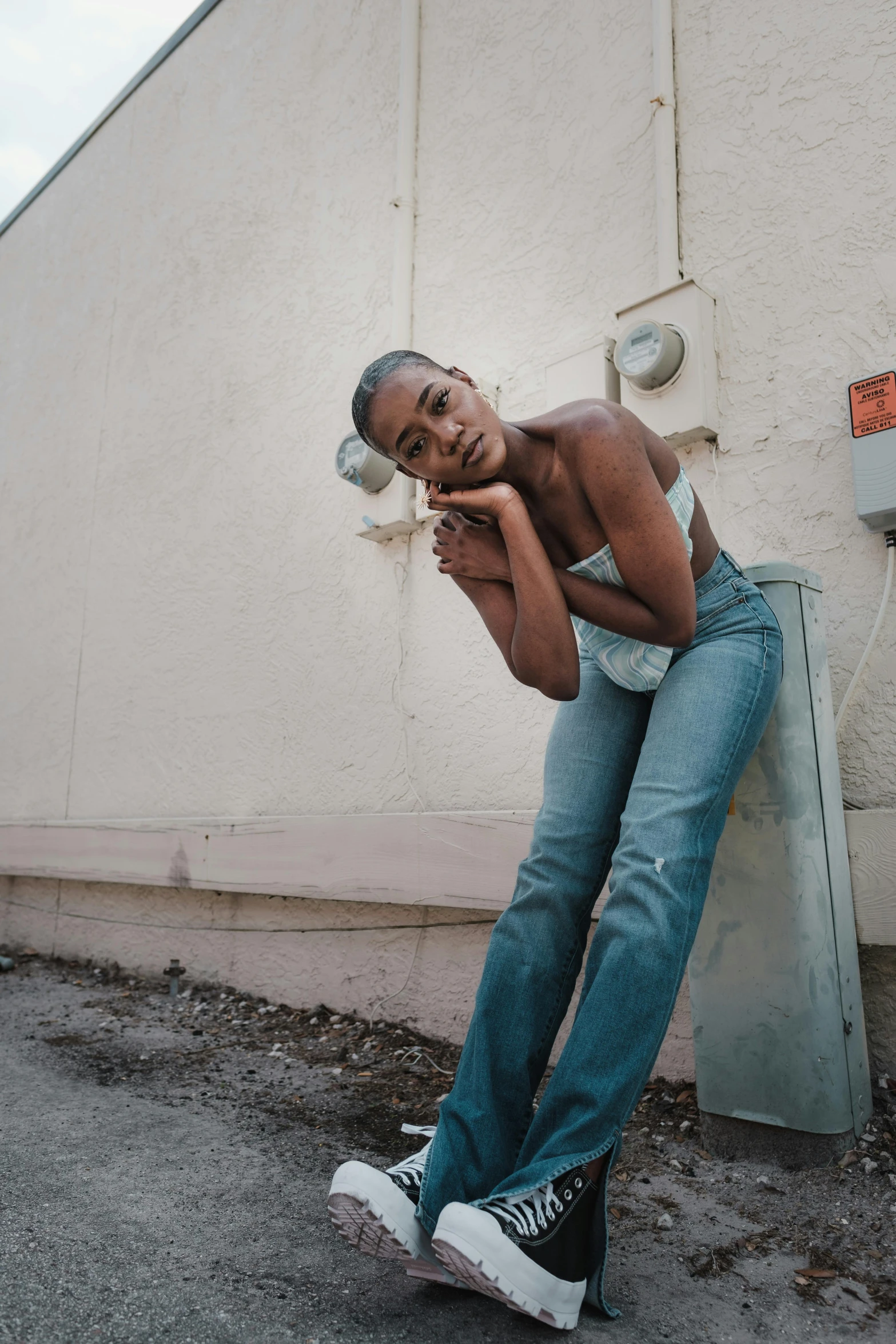 a person leaning against a wall with a cellphone