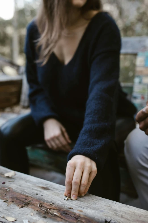 a woman sits on a bench holding the edge of the board