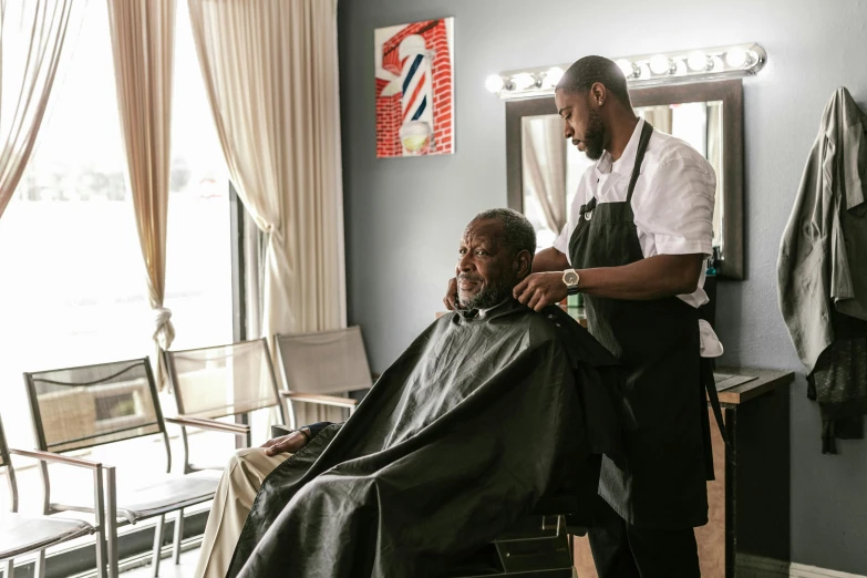 the man is getting his hair cut at the barber