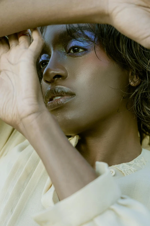 a woman wearing a cream colored outfit posing for the camera