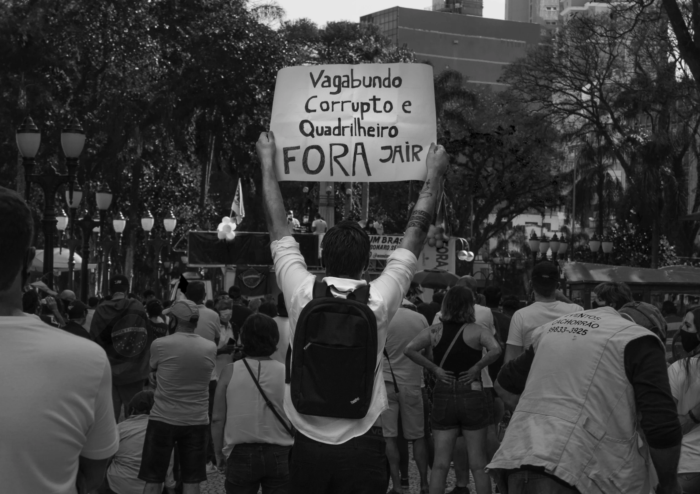 a crowd of people holding signs and bags