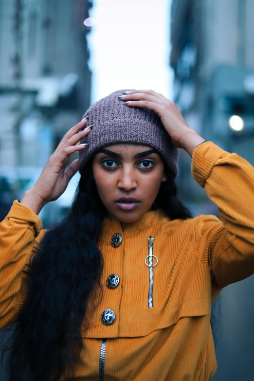 a woman wearing a brown hat and yellow jacket