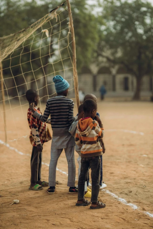 two boys standing near a soccer net on the ground