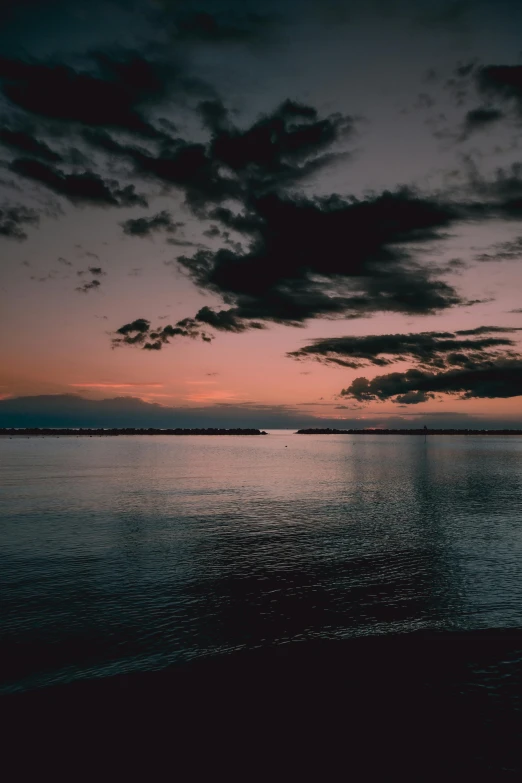 a body of water at sunset with a sky background