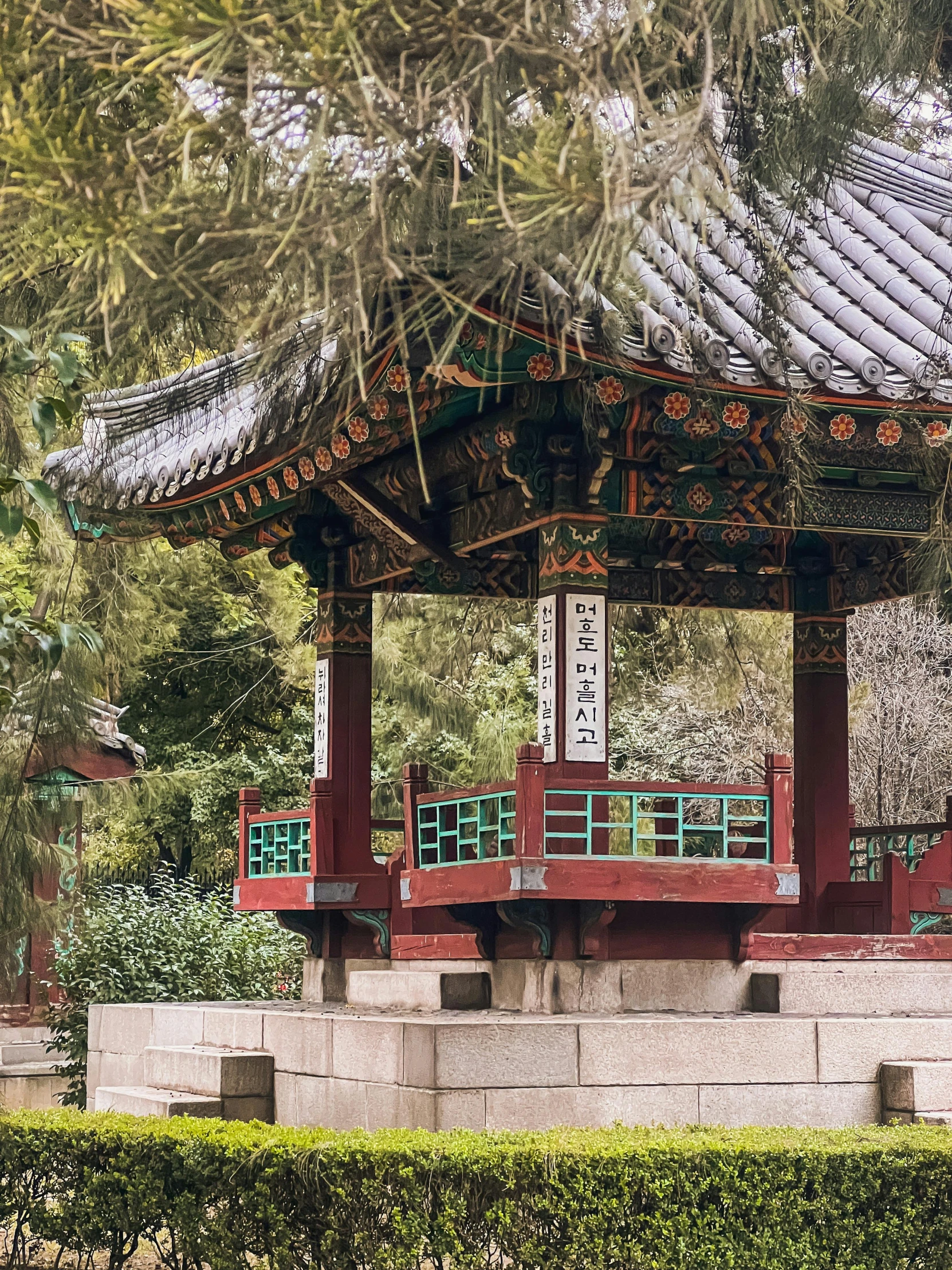 a chinese style structure with green plants in the background