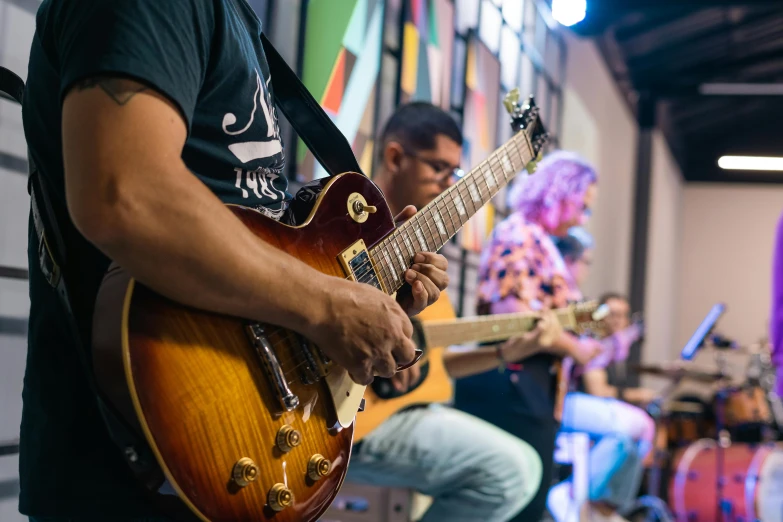 man playing guitar next to other musical instruments