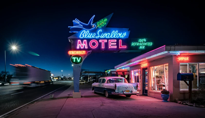 neon signs on the side of motels and shops