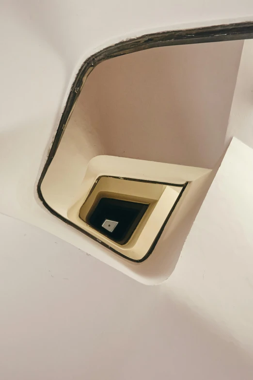 an unusual shaped window and floor inside a toilet