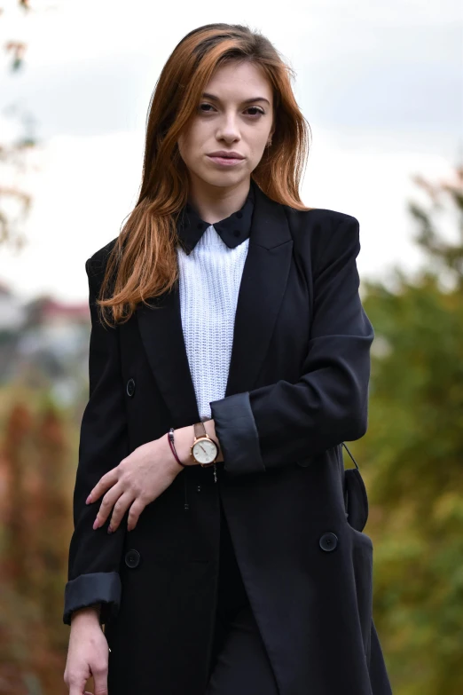 the woman in the jacket is posing outside