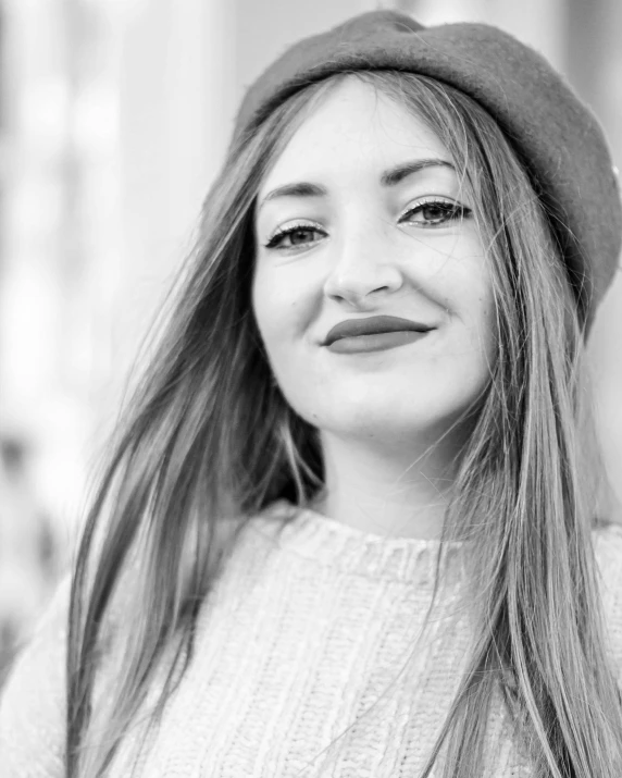 a young woman is smiling and wearing a hat