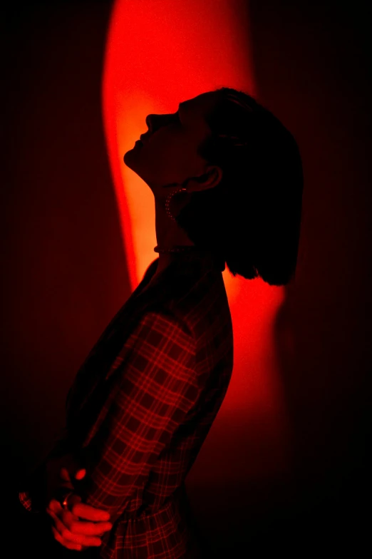 a person in front of a wall in a red lit room