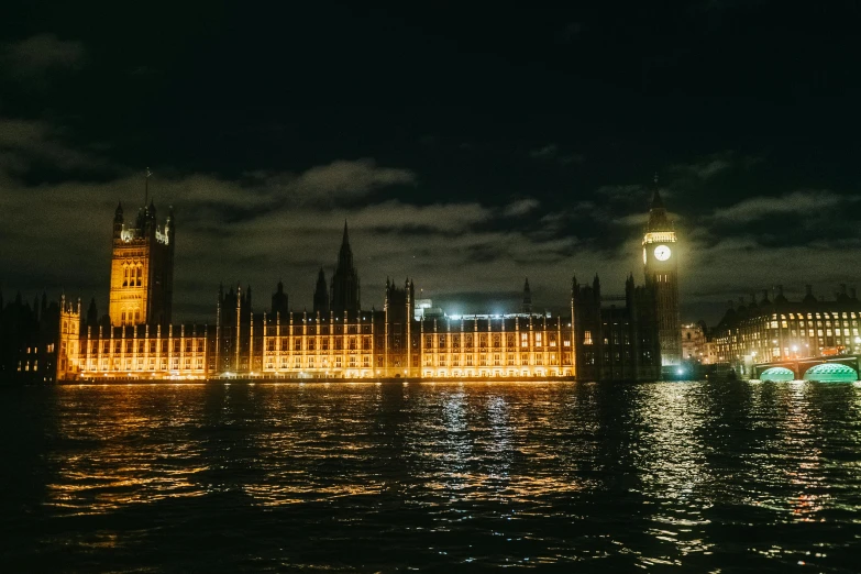 a building next to the water with lights in front of it