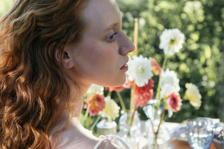 there is a woman standing by a table with flowers in her hair