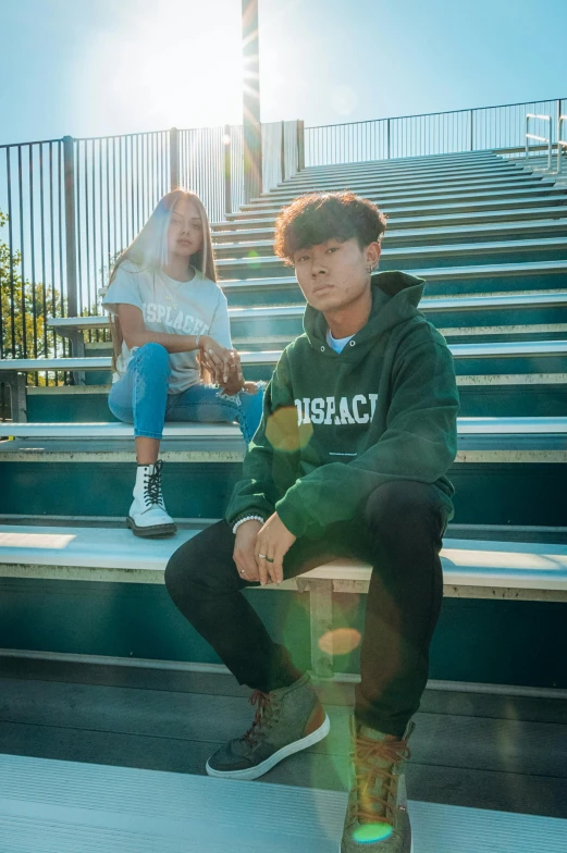 two young people sitting on the steps and one wearing sneakers