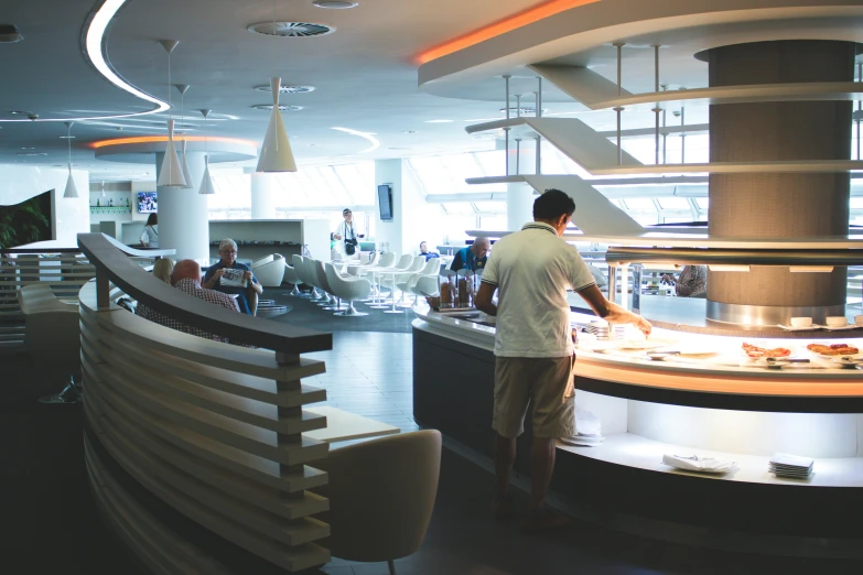 man standing at the bar looking down over food