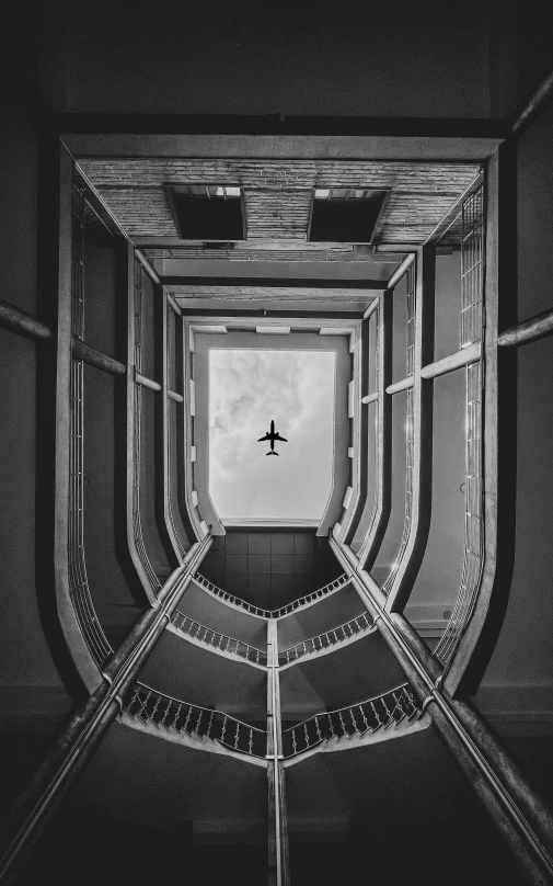 a plane is flying in the sky from the bottom floor of a building