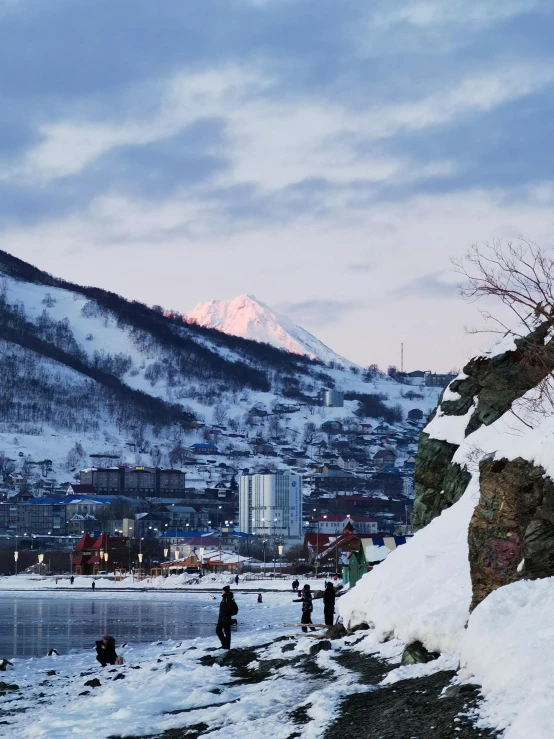 several people near some snow on the shore