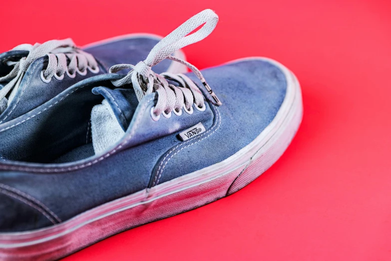 a pair of gray sneakers sitting on top of a red floor