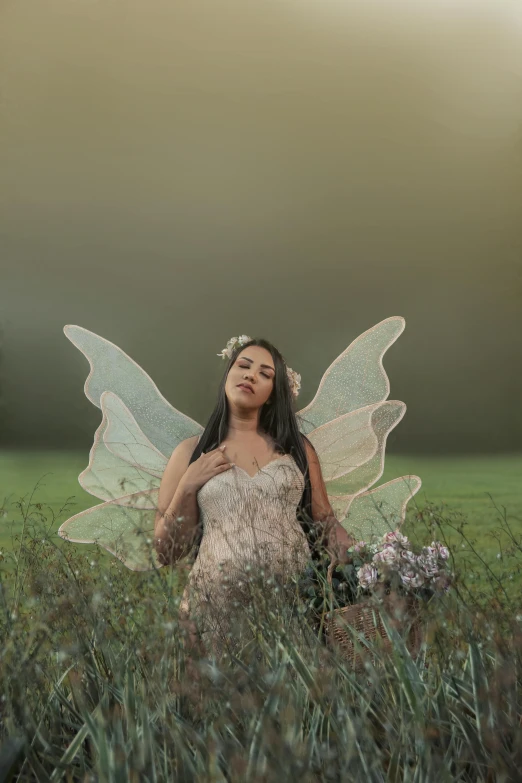 a girl wearing a fairy outfit standing in the grass