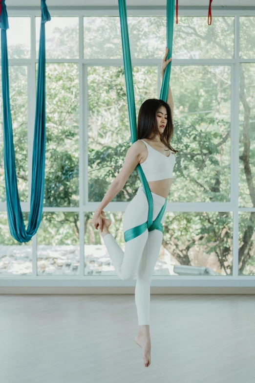 an asian girl posing in front of window, with ribbon attached to a curtain