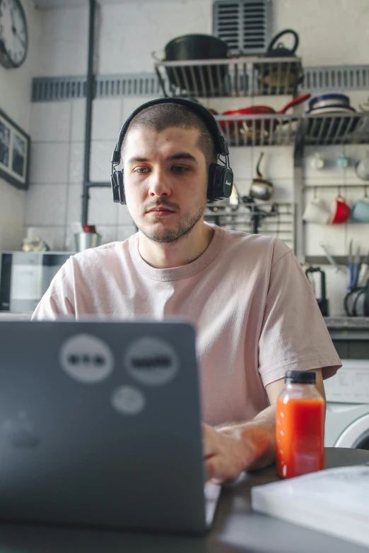 a man with headphones sitting in front of a laptop