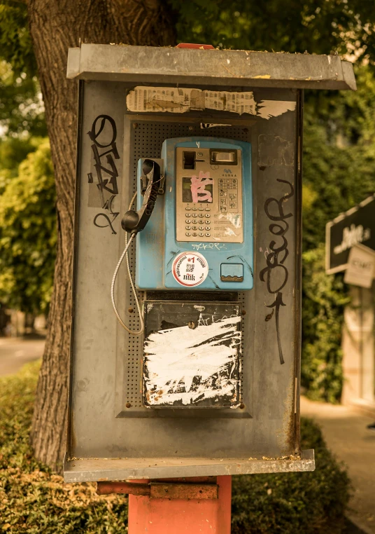 an old - fashioned pay phone is displayed in the street