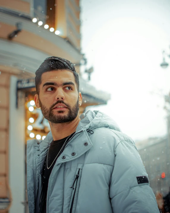 a man is standing near some buildings in the snow