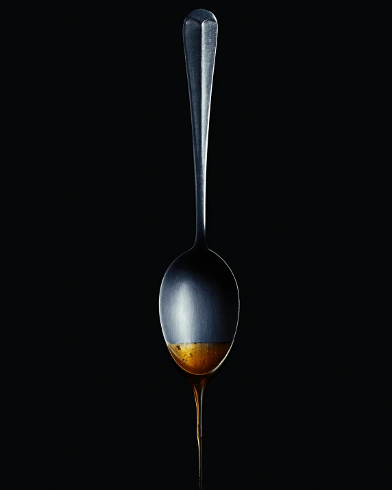 an empty spoon with oil running down it