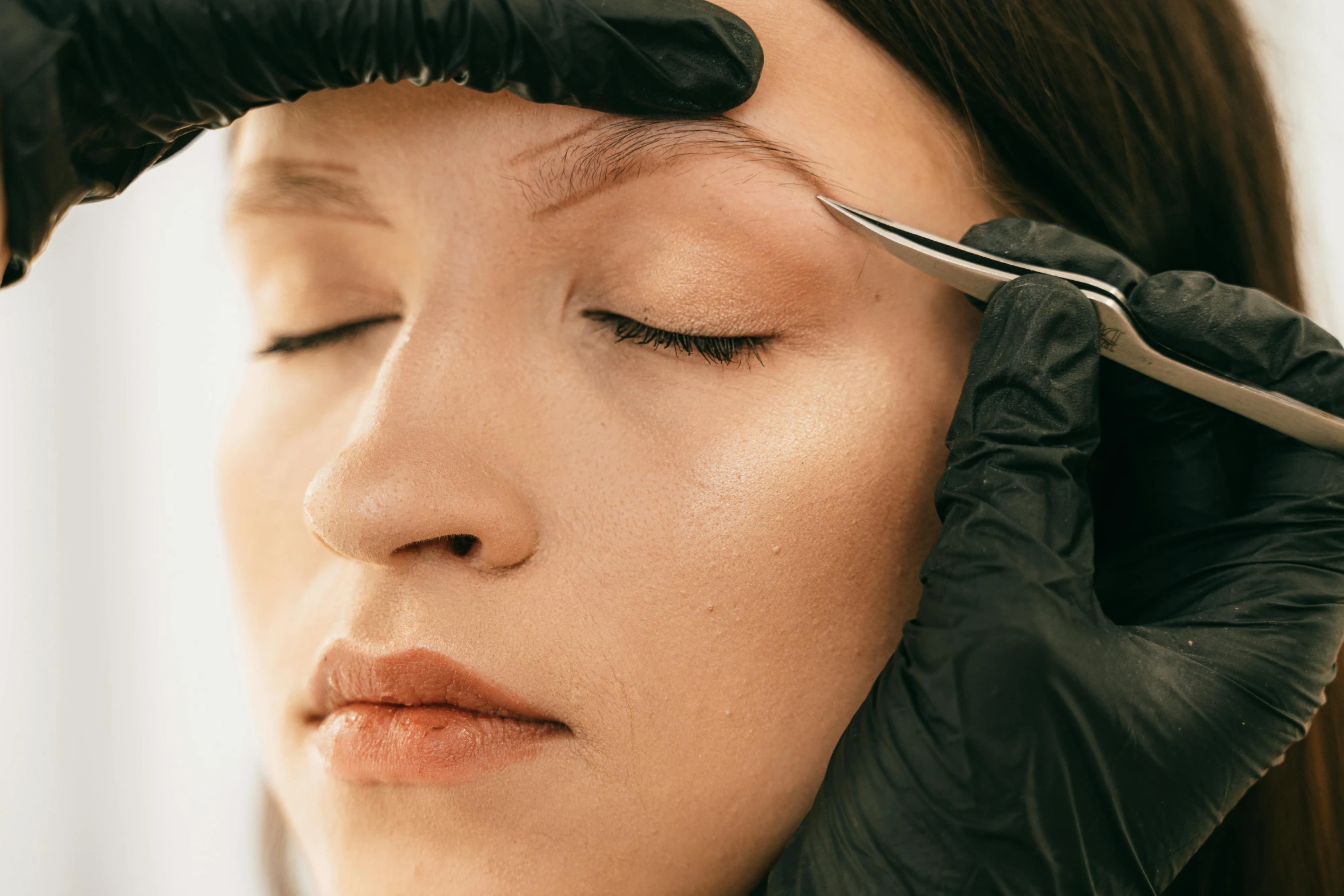 a woman getting her eyebrows touched while getting ready to go