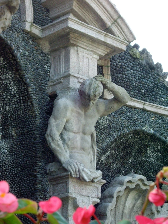 a statue stands on top of an ornate planter