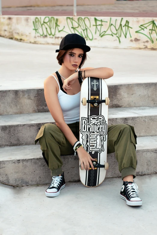 young woman sitting with skateboard at steps in urban area