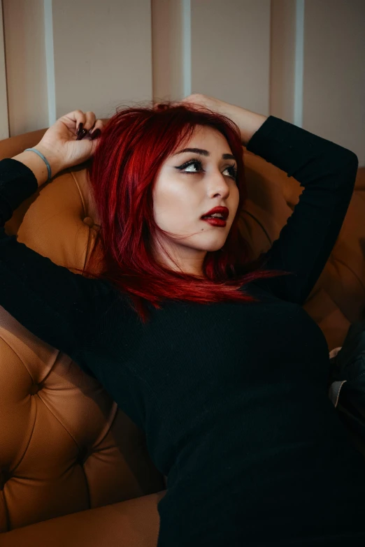 a woman is sitting on a couch with her hand under her head