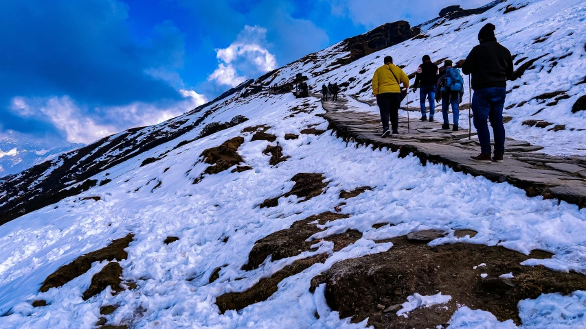 a group of people walking along a snow covered hill