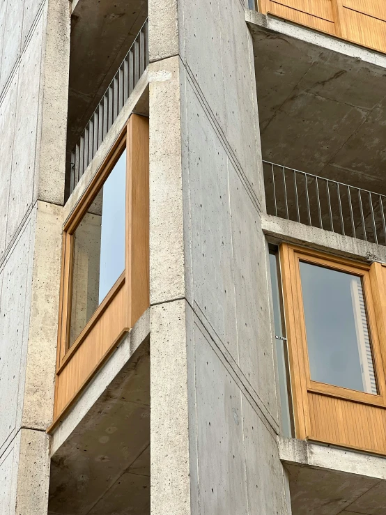a concrete building that has wooden balconies on each of the windows