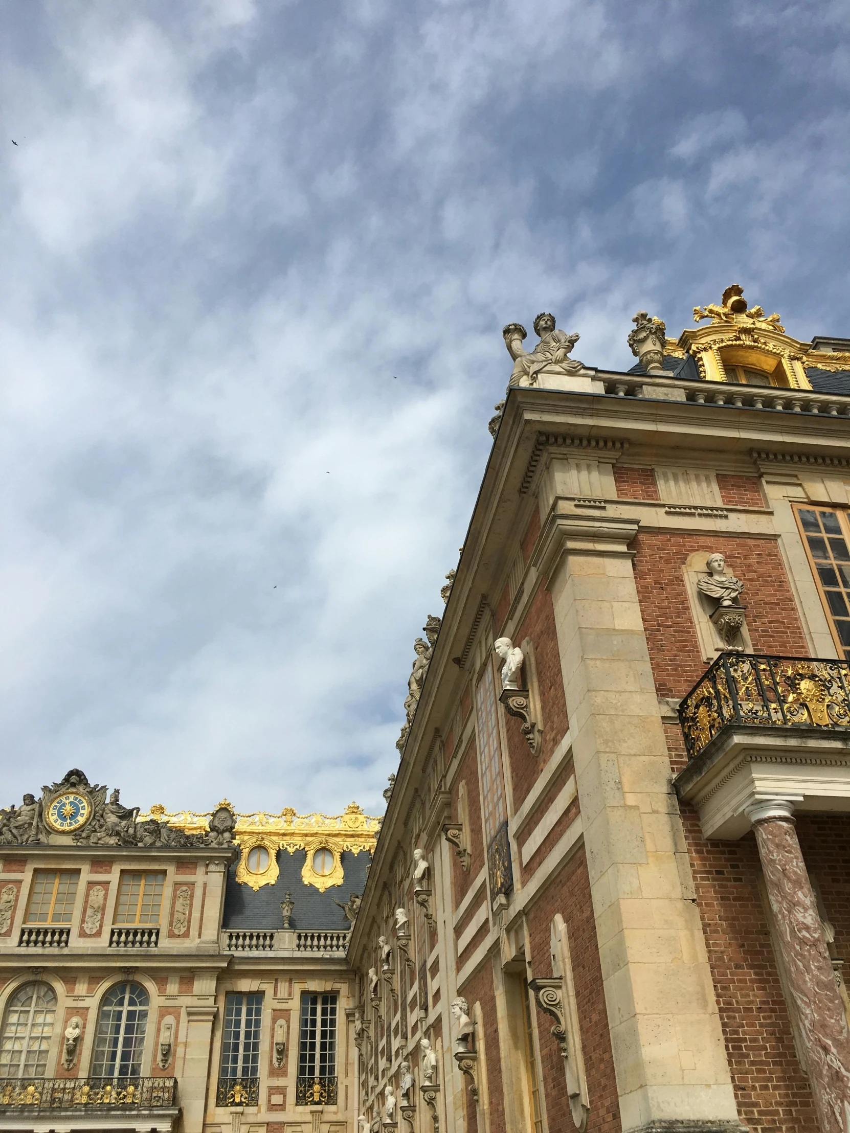 a building with gold and statues on top