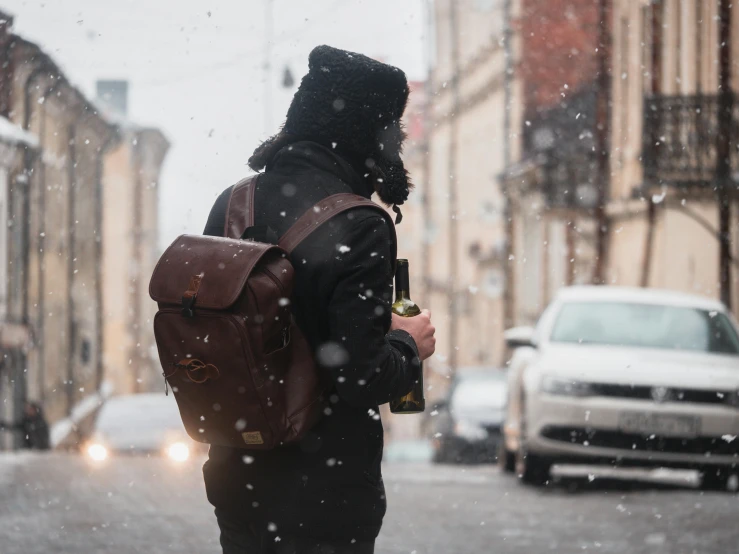 a man is standing on the street in the snow