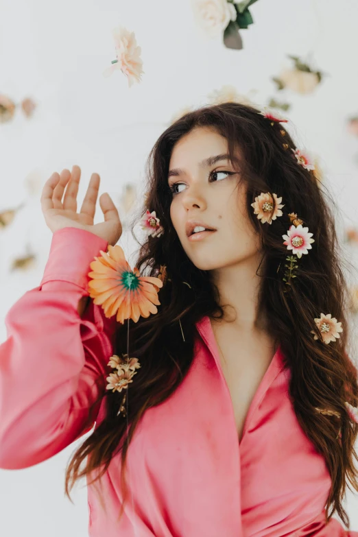 the woman in pink coat is wearing flowers