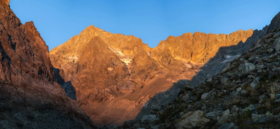 mountains in the sunset glow brightly from their shadow