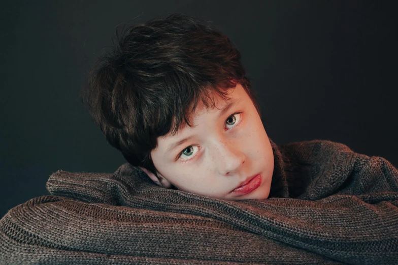 a young person with blue eyes sitting on a couch